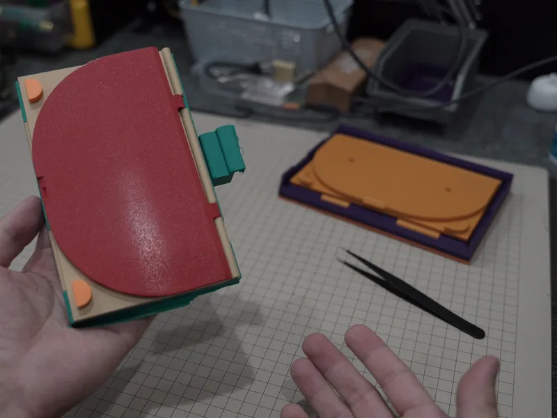 A prototype with a red lid, a cable catch on its side