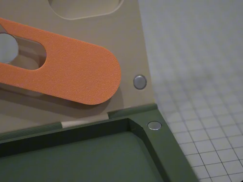 Close-up of the olive tray with small round magnets set flush, an orange part above