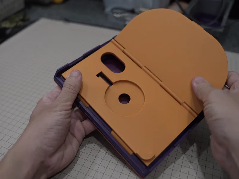 The first prototype, orange, 3D-printed, opened up