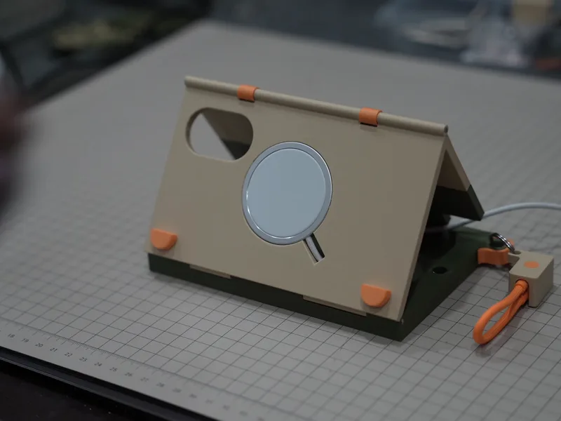 The dock standing open on a cutting mat, sand-coloured face with the MagSafe puck