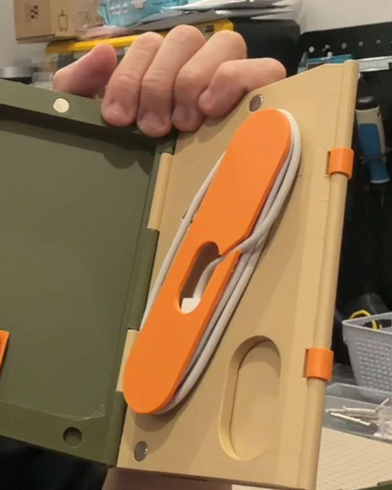 The dock open, olive interior with the orange cable spindle