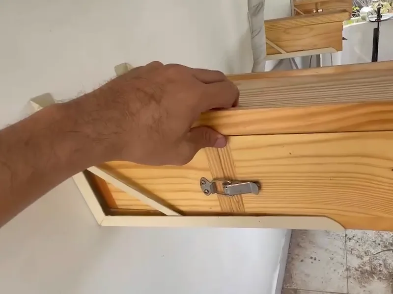 Một thùng gỗ nuôi ong dú gắn trên tường, cạnh vườn cây