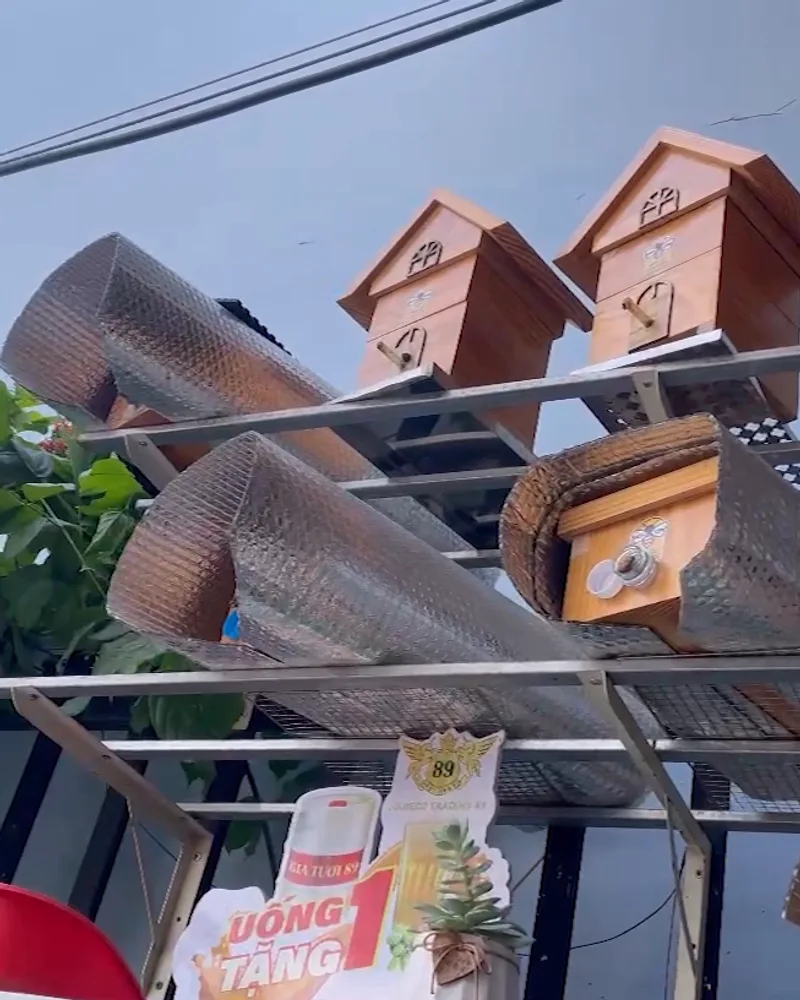 Nhiều thùng ong dú bằng gỗ xếp trên giá sắt ngoài trời