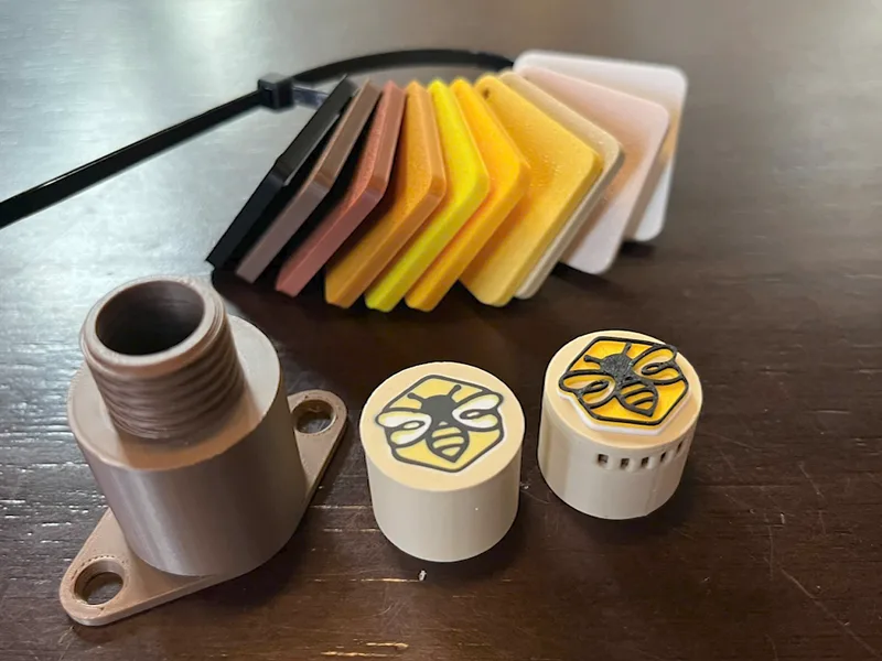 Cửa chính màu nâu, hai nắp có logo con ong, và một bảng màu nhựa xếp hình quạt
