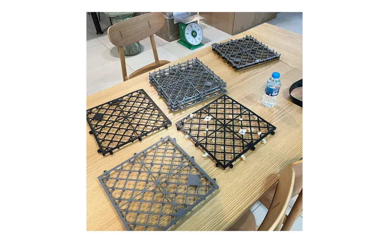 Photos of black and grey plastic floor tiles on a table